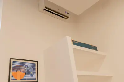 a white kitchen with a ceiling fan and a picture at Domus Aura in Rome