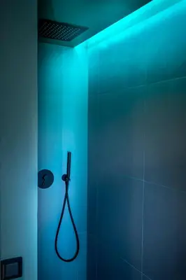 a bathroom with a shower with a blue light at Gracchi39 Apartment in Rome