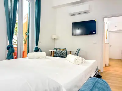 a bedroom with a bed with a tv on the wall at Modern apartment with Private Balcony Near Colosseum in Rome