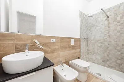 a bathroom with a sink and a toilet and a shower at Black Rooms Colosseo in Rome
