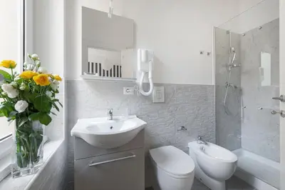 a bathroom with a sink and a toilet and a mirror at Black Rooms Colosseo in Rome