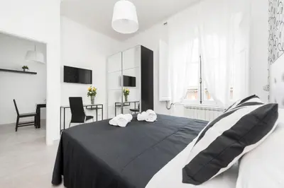 a bedroom with a bed with two towels on it at Black Rooms Colosseo in Rome