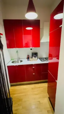 a kitchen with red cabinets and a sink at Anna Stellarum in Rome