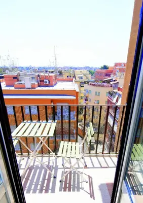 a balcony with two chairs and a view of a city at San Giovanni Suite Rome in Rome