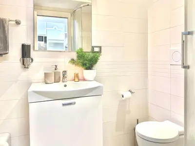 a white bathroom with a sink and a toilet at San Giovanni Lulus Home in Rome