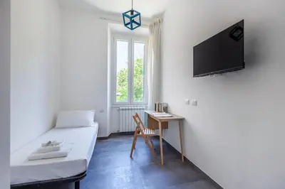 a room with a bed and a table and a tv at Ponte Milvio 3 Bedroom Apartment in Rome