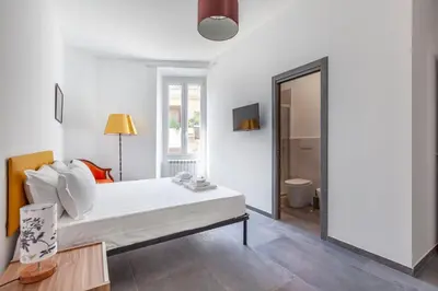 a white bedroom with a bed and a bathroom at Ponte Milvio 3 Bedroom Apartment in Rome