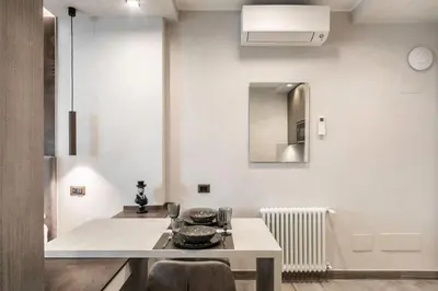 a white kitchen with a table with dishes on it at Junior Deluxe in Rome