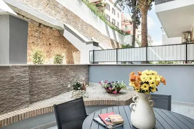 a patio with a table and a vase of flowers at Junior Deluxe in Rome