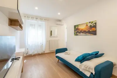 a bedroom with a bed with a blue chair in it at Ponte Milvio-Olympic Stadium Modern Apartment in Rome
