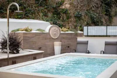 a hot tub in a patio with two chairs at Pool & Spa Deluxe in Rome