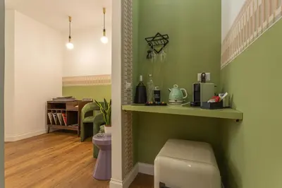 a room with green walls and a shelf and a table at Eufonia Vatican Golden Suites in Rome