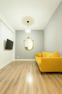 a living room with a yellow couch and a mirror at Sole 34 Apartment in Rome