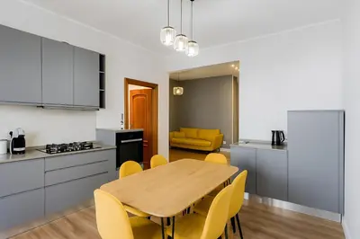 a kitchen and dining room with a wooden table and yellow chairs at Sole 34 Apartment in Rome