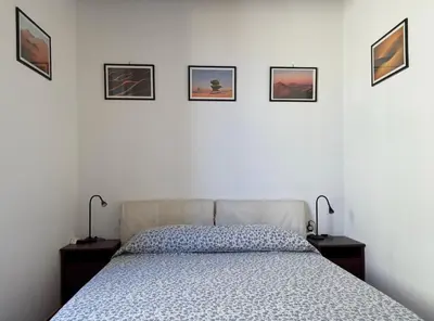 a bedroom with a bed and four pictures on the wall at Finestre sul Tevere in Rome