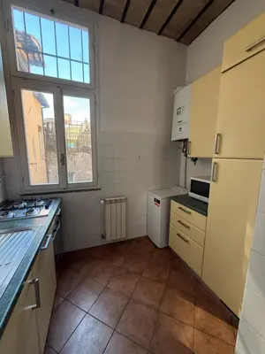 a kitchen with white appliances and a large window at Finestre sul Tevere in Rome