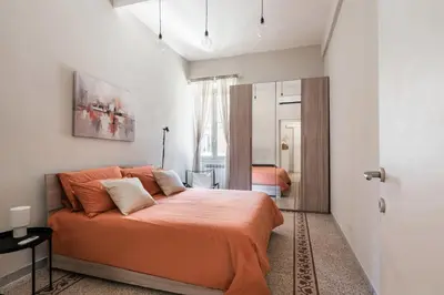 a bedroom with a bed with an orange blanket at Maggiore Home in Rome