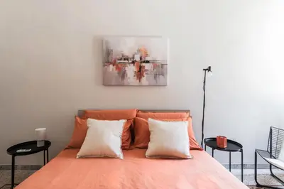 a bed with two pillows and a painting on the wall at Maggiore Home in Rome