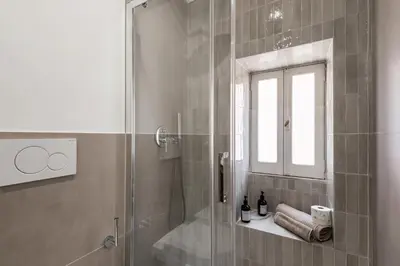 a bathroom with a shower with a sink and a mirror at Maggiore Home in Rome