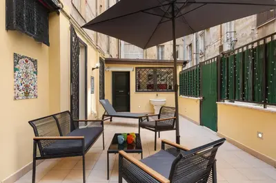 a patio with chairs and a table and an umbrella at Quintino Terrace Apartment near Termini Station in Rome