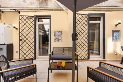 a patio with two benches and a table with drinks on it at Quintino Terrace Apartment near Termini Station in Rome