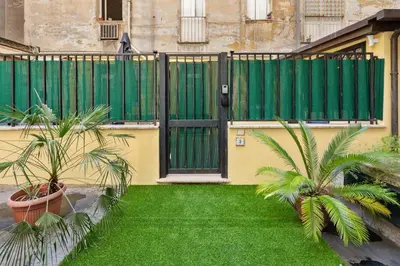 a fence with a green gate and two palm trees at Quintino Terrace Apartment near Termini Station in Rome