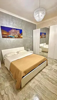 a bedroom with a large bed and a chandelier at Cataldo Suites Roma in Rome