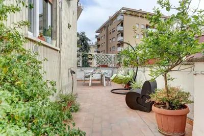 a patio with plants and a table on a balcony at Delizioso attico con terrazzo in Rome