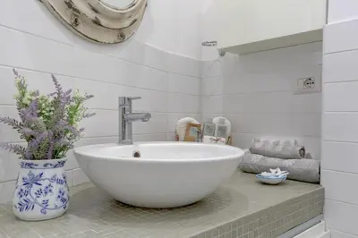 a bathroom with a bowl sink and a vase with flowers at Delizioso attico con terrazzo in Rome