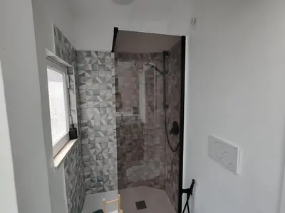 a bathroom with a shower with a stone wall at Veronica House in Rome