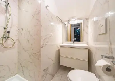 a white bathroom with a toilet and a sink at Domus Aventino Apartment in Rome