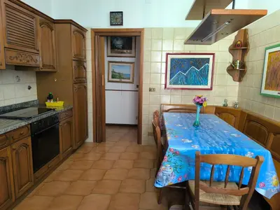 a kitchen with a table with a vase of flowers on it at Artist's House Colosseum in Rome
