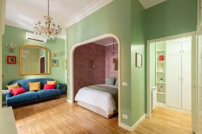 a bedroom with a bed and a blue couch at Rome Dreamer Suite in Rome