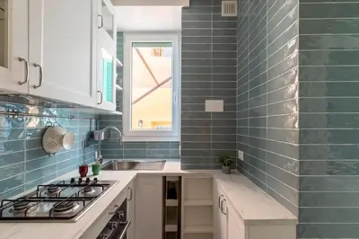 a kitchen with blue tiles on the wall and a sink at Rome Dreamer Suite in Rome