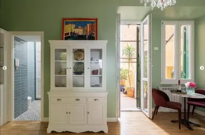 a dining room with a white hutch and a table at Rome Dreamer Suite in Rome