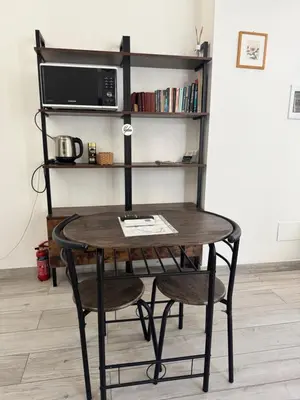 a table with a chair and a microwave on a shelf at La Casetta Monteverde in Rome