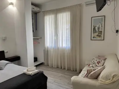 a bedroom with a bed and a couch and a window at La Casetta Monteverde in Rome