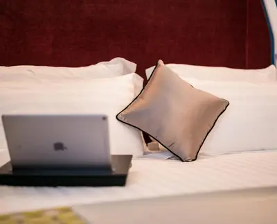 a laptop computer sitting on a bed with a pillow at Jb Relais Luxury in Rome
