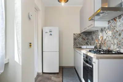 a kitchen with a refrigerator and a stove at Conca D'Oro Guest House - Anna in Rome