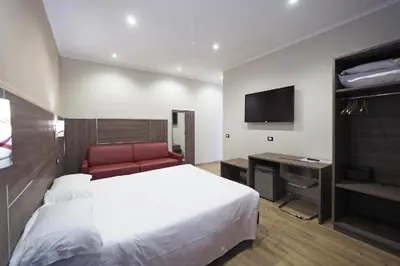 a hotel room with a bed and a flat screen tv at Osimar Rooms in Rome