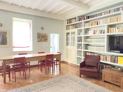 a living room with a blue couch and bookshelves at Monti - Colosseum - Boschetto Vintage - 2BR in Rome