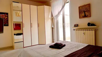 a bedroom with a bed and a large window at Entire Flat at Last floor in Piazza Bologna in Rome