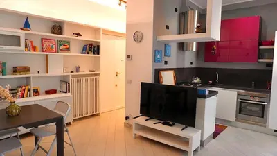 a kitchen with red cabinets and a tv on a table at Entire Flat at Last floor in Piazza Bologna in Rome