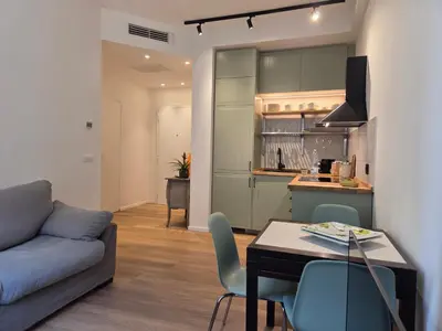 a living room with a couch and a table and a kitchen at Maison Viola in Rome