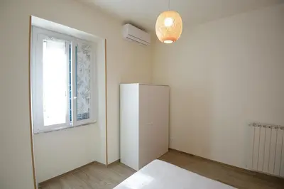 a room with a white refrigerator and a window at Appartamento Iris in Rome