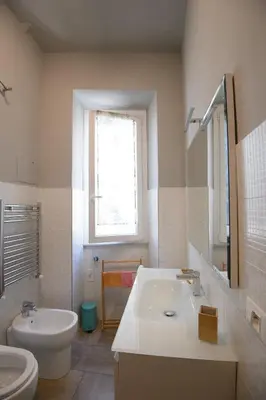 a white bathroom with a sink and a toilet at Appartamento Iris in Rome