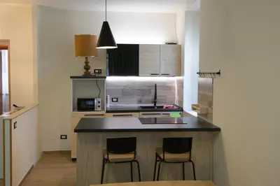 a kitchen with a island with two bar stools at Appartamento Iris in Rome
