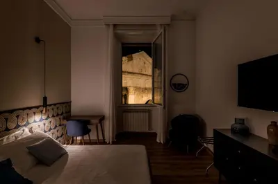 a bedroom with a bed and a window with a television at The Best Rent - Three-Room Apartment with View of the Portico d'Ottavia in Rome