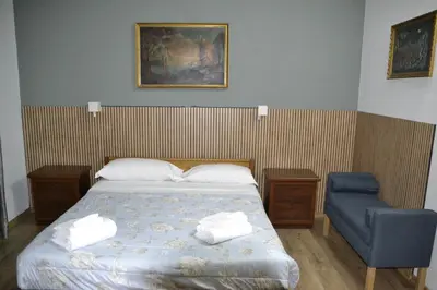 a bedroom with a bed and a blue chair at Aurora Boreale in Rome