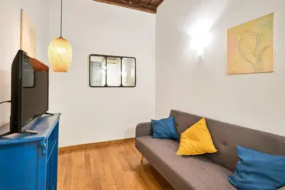 a living room with a couch and a tv at Trinity Apartment in Rome